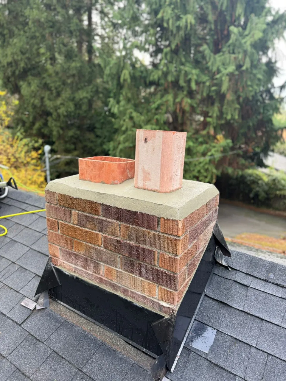 A repointed brick chimney with new flashing on a North Jersey roof