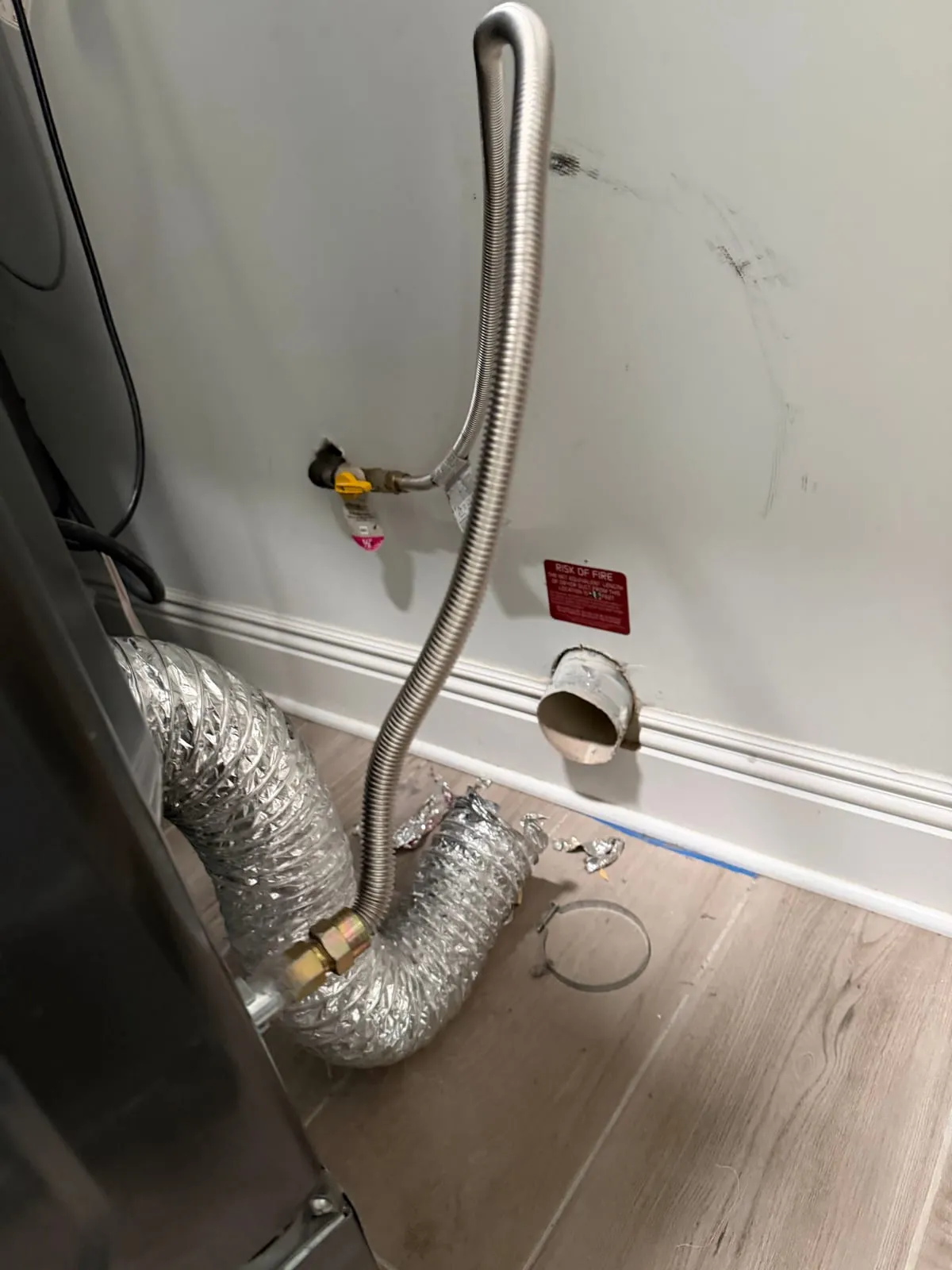 Flexible ducting connected behind a machine in a laundry room